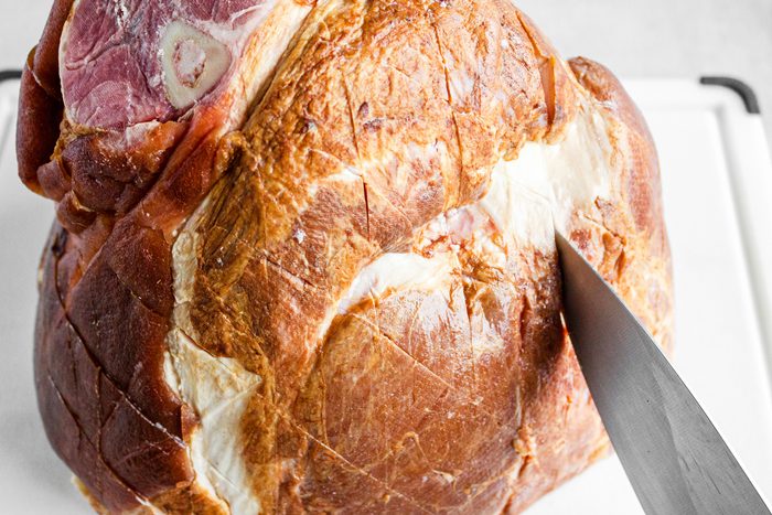 3/4th shot; white background; ham; with knife