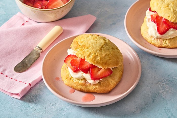 Angled shot of two strawberry lemon shortcakes filled with cream and strawberries