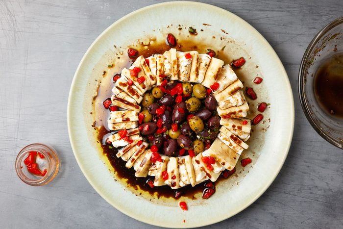 Step 2 of Taste of Home Olives & Cheese is to whisk the vinegar, olive oil, parsley, basil and garlic until blended, then drizzle the mix over the cheeses and olives. Sprinkle the pimientos over the top. Refrigerate the plate, covered, for at least eight hours or overnight. Serve with baguette slices.