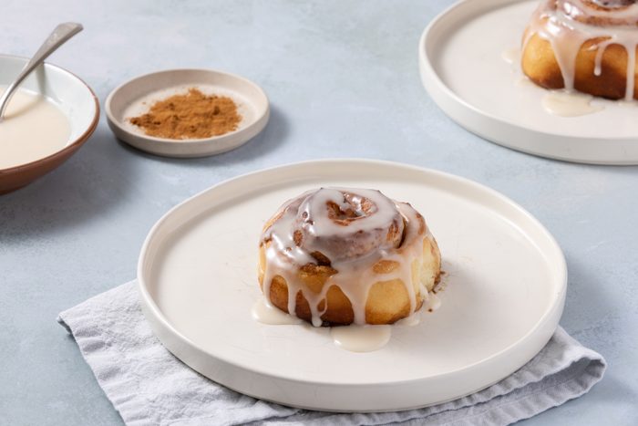 Cinnamon rolls baked and glazed served on plates.