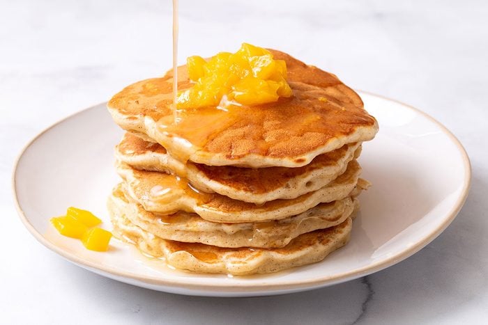Peach Pancakes on a plate with drizzled butter syrup
