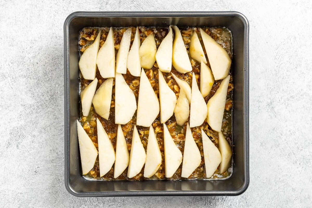 Taste of Home Pear Upside Down Cake recipe photo of the prepared pan with butter, nuts, brown sugar and pears.