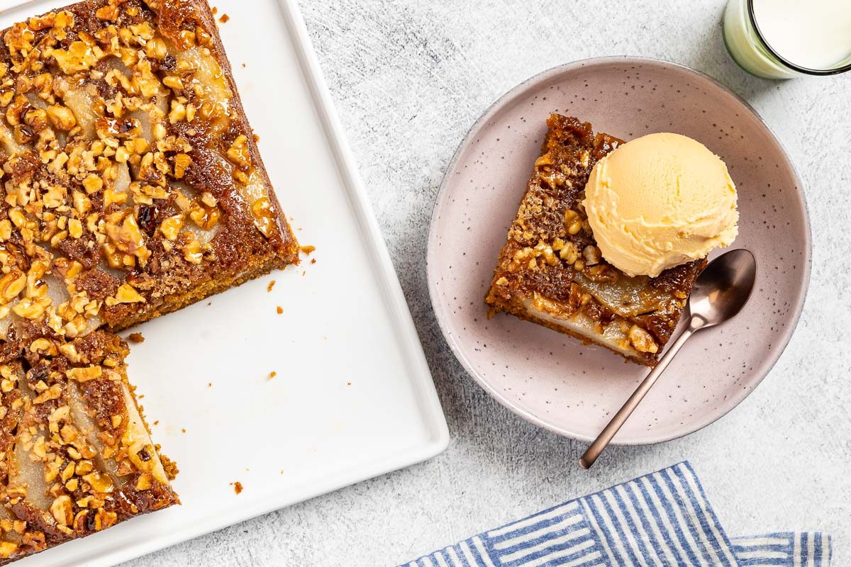 Taste of Home Pear Upside Down Cake recipe photo of the finished cake cute into a slice and topped with ice cream.