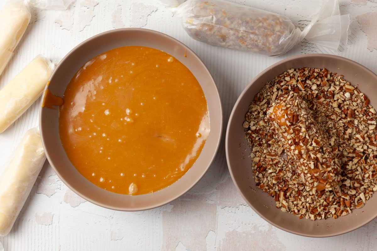 Step 5 of Taste of Home Pecan Logs is to place the caramels and milk or half-and-half into a microwaveable bowl or measuring cup. Heat them, stirring frequently, until the caramels melt smoothly into the milk. Roll the logs in the caramel mixture and then into the chopped pecans. Wrap the logs again in waxed paper