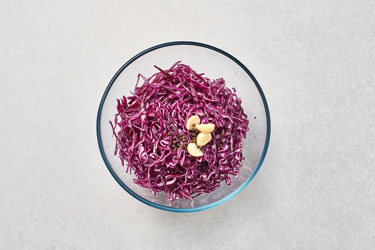 Red cabbage garlic and peppercorns in a large bowl