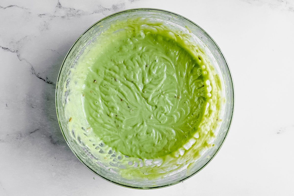 Batter for Taste of Home Pistachio Bundt Cake in a glass bowl on a marble surface