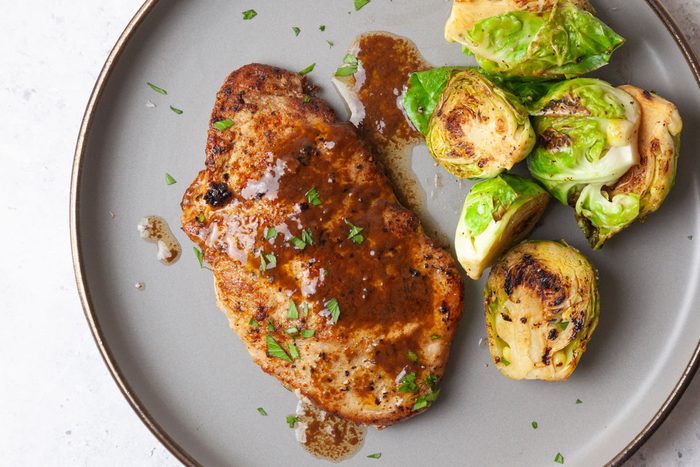 Single servingd of Taste of Home Pork Diane on a gray plate with brussels sprouts