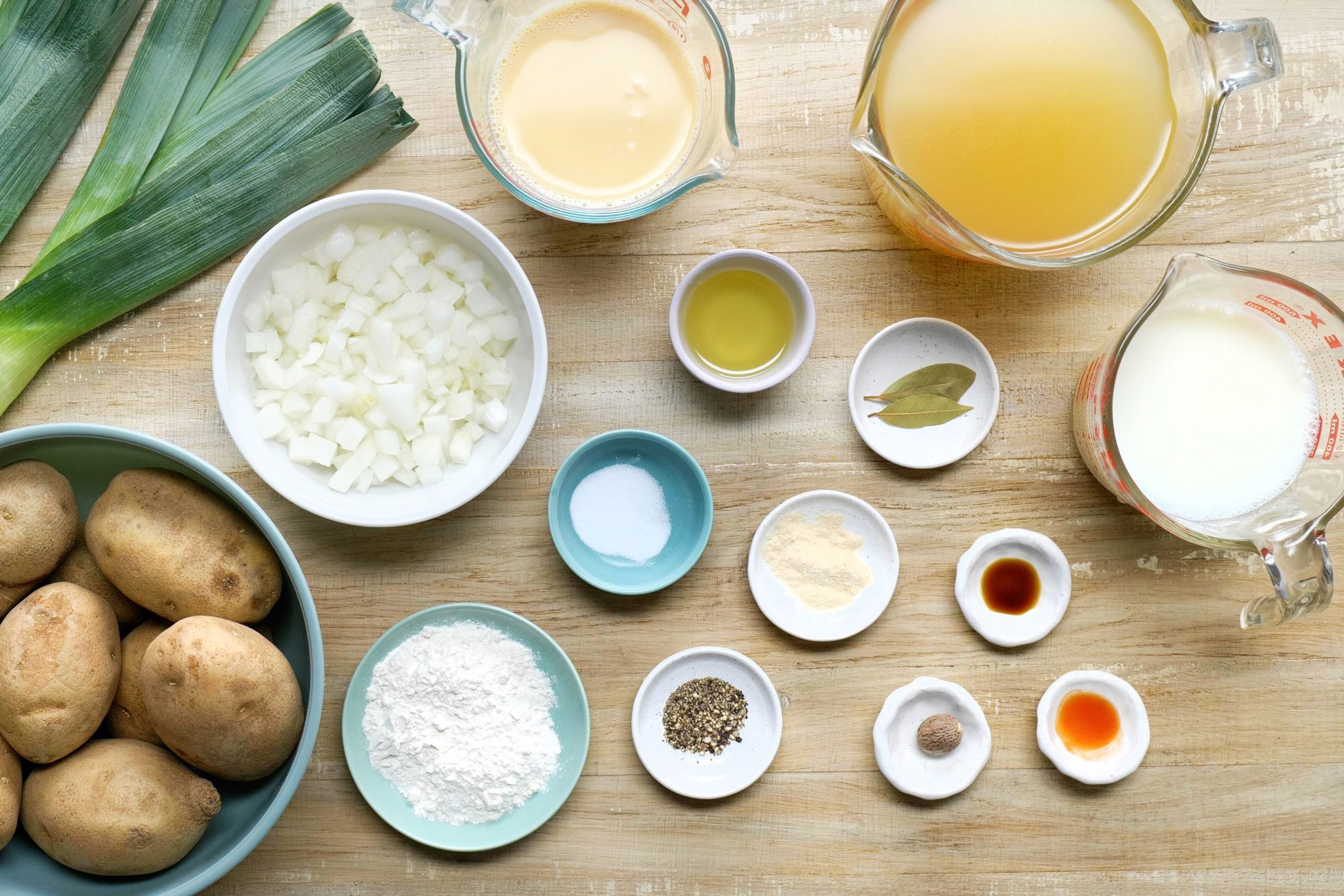 overhead shot; wooden background; Potato Leek Soup ingredients placed over background;