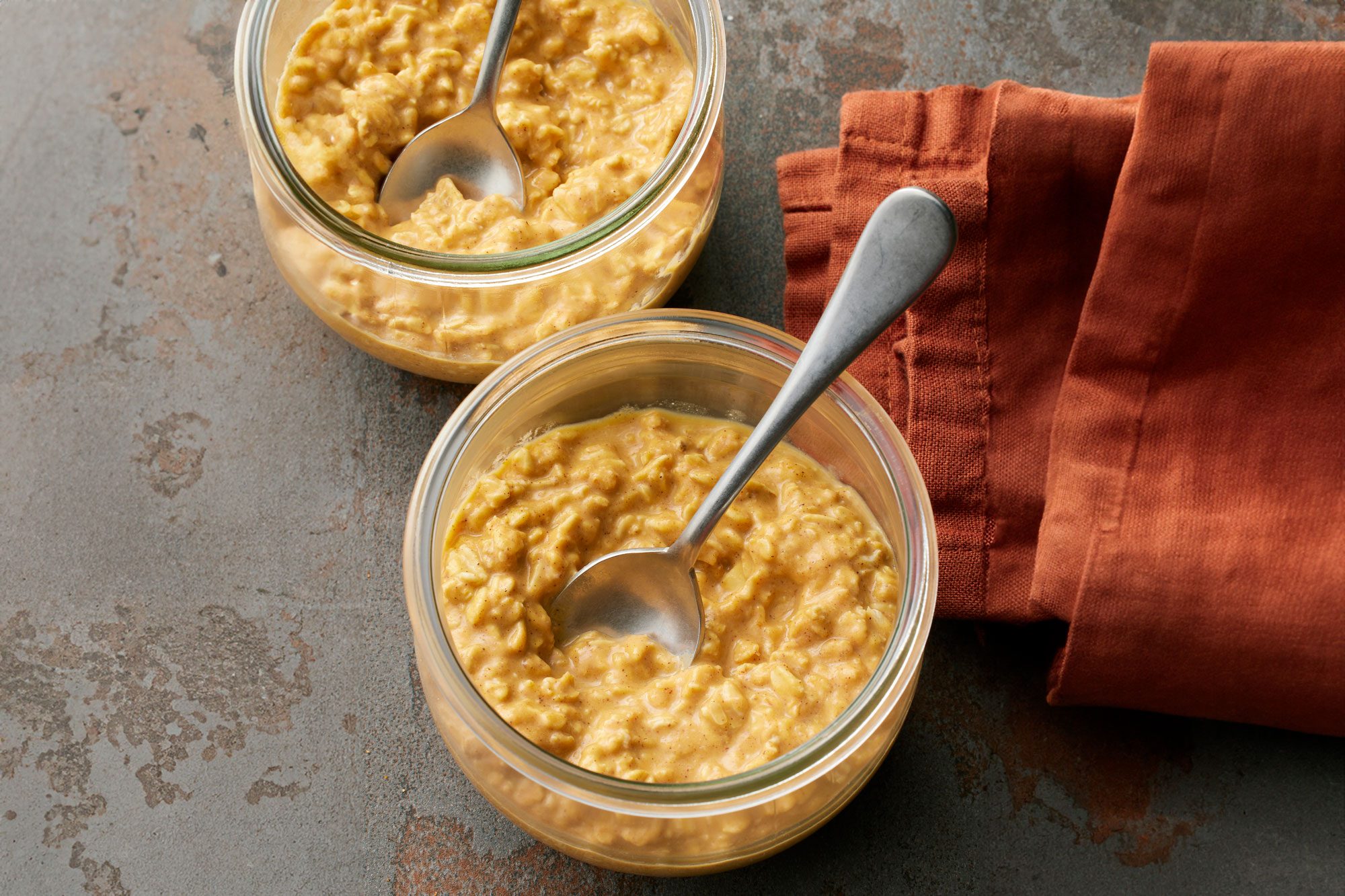 Pumpkin Overnight Oats in two containers with spoon