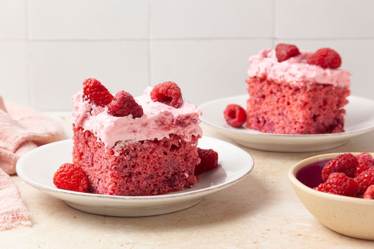 Two slices of Taste of Home Raspberry Cake garnished with fresh raspberries