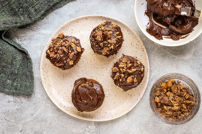 Peanut butter cup cupcakes with peanut butter cup crumbs sprinkled over the chocolate frosting.