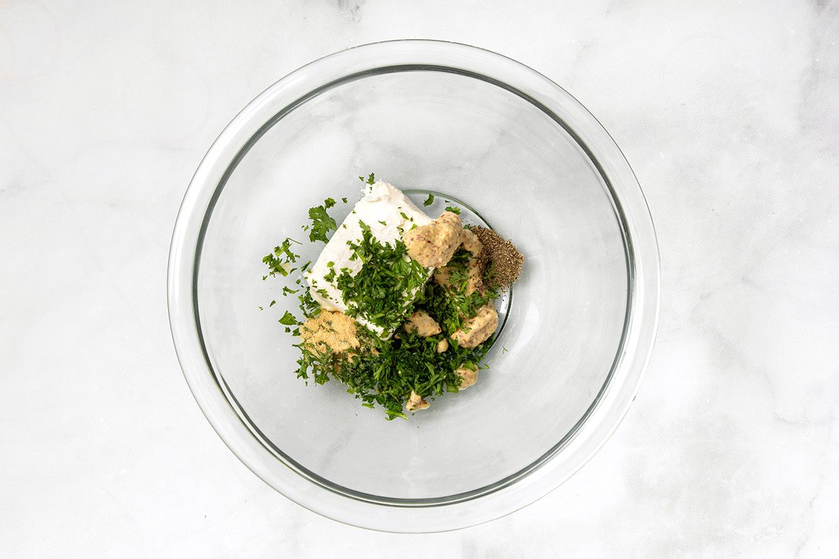 Cream cheese, mustard, parsley and ground pepper in mixing bowl for step 2 for Sauerkraut Balls for Taste of Home