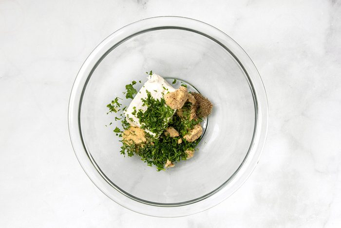 Cream cheese, mustard, parsley and ground pepper in mixing bowl for step 2 for Sauerkraut Balls for Taste of Home
