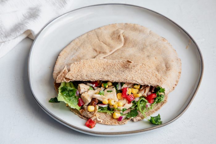 Beauty Shot for Taste of Home Southwest Chicken Salad in a pita with salad greens on a plate.