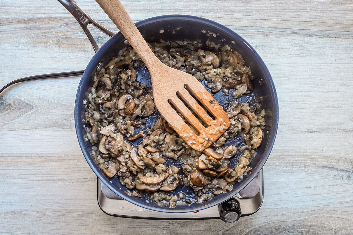 Sliced mushrooms and onions are sautéed for spinach risotto from Taste of Home.