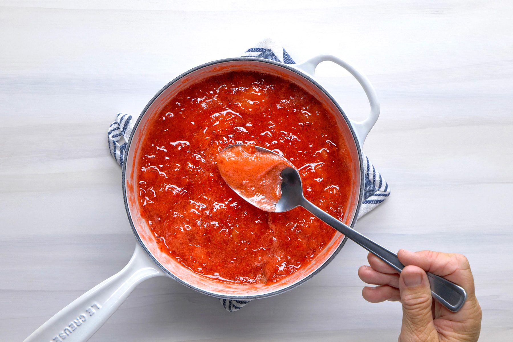 Overhead shot of remove from heat; skim off foam; spoon; wooden surface