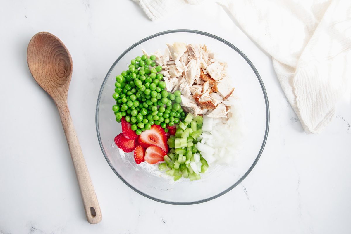 Overhead shot for Taste of Home Tarragon Chicken Salad with ingredients in glass bowl, not mixed.
