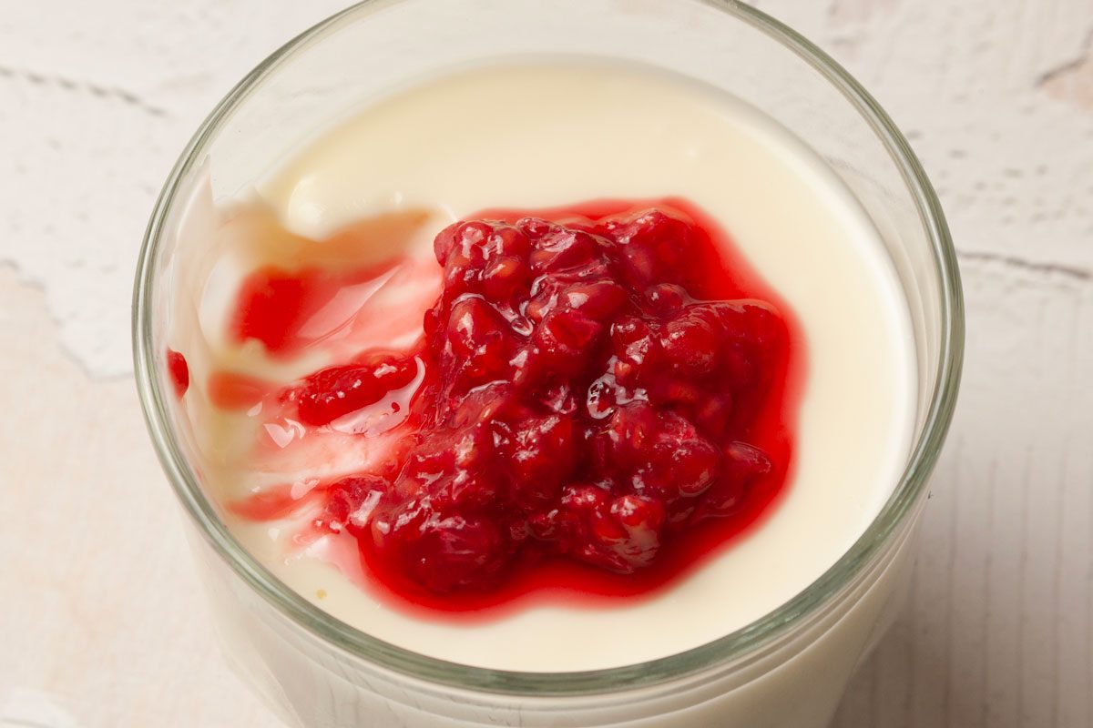 Close up of one single servings of Taste of Home Swedish Creme garnished with mashed raspberries, scoop out
