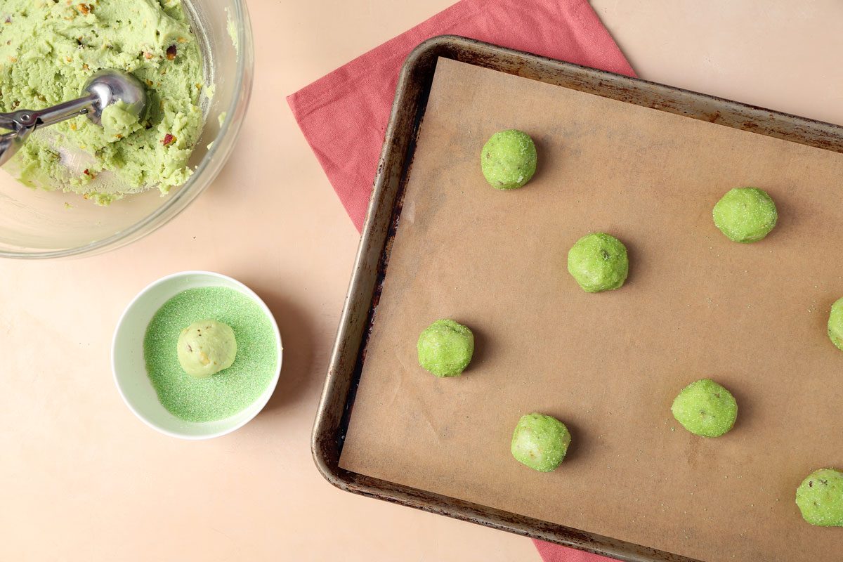 The process of making Taste of Home's Pistachio Cookies on a baking sheet with cookie dough in a large bowl.