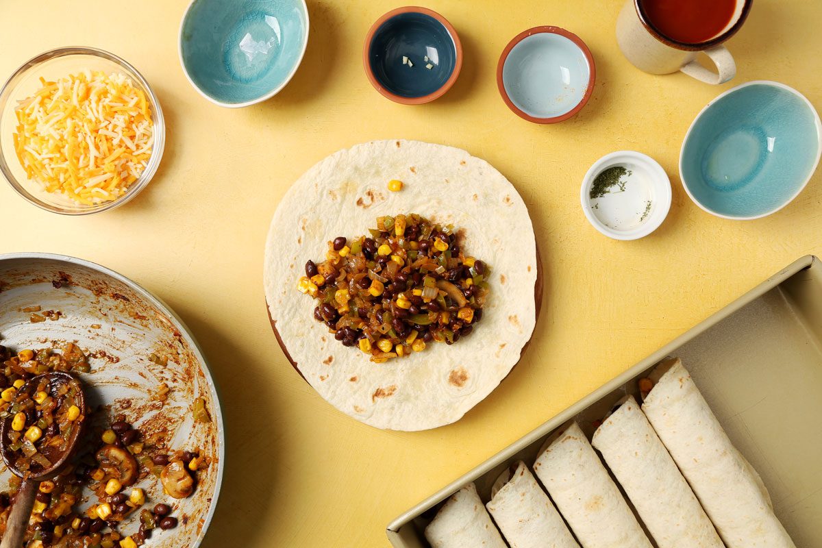 Making Taste of Home's Vegetarian Enchiladas with different ingredients laid out on a yellow surface.