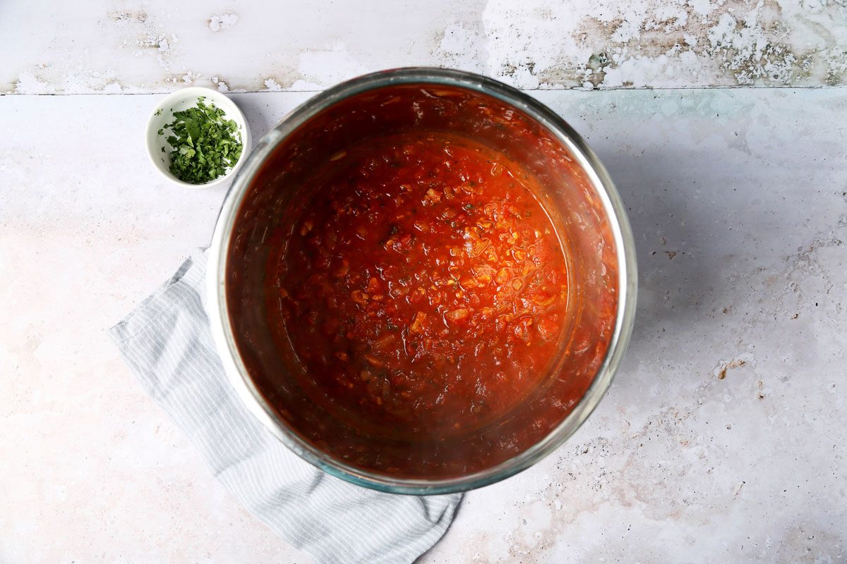 Cooking Taste of Home's Red Clam Sauce in a slow cooker on a grey background.