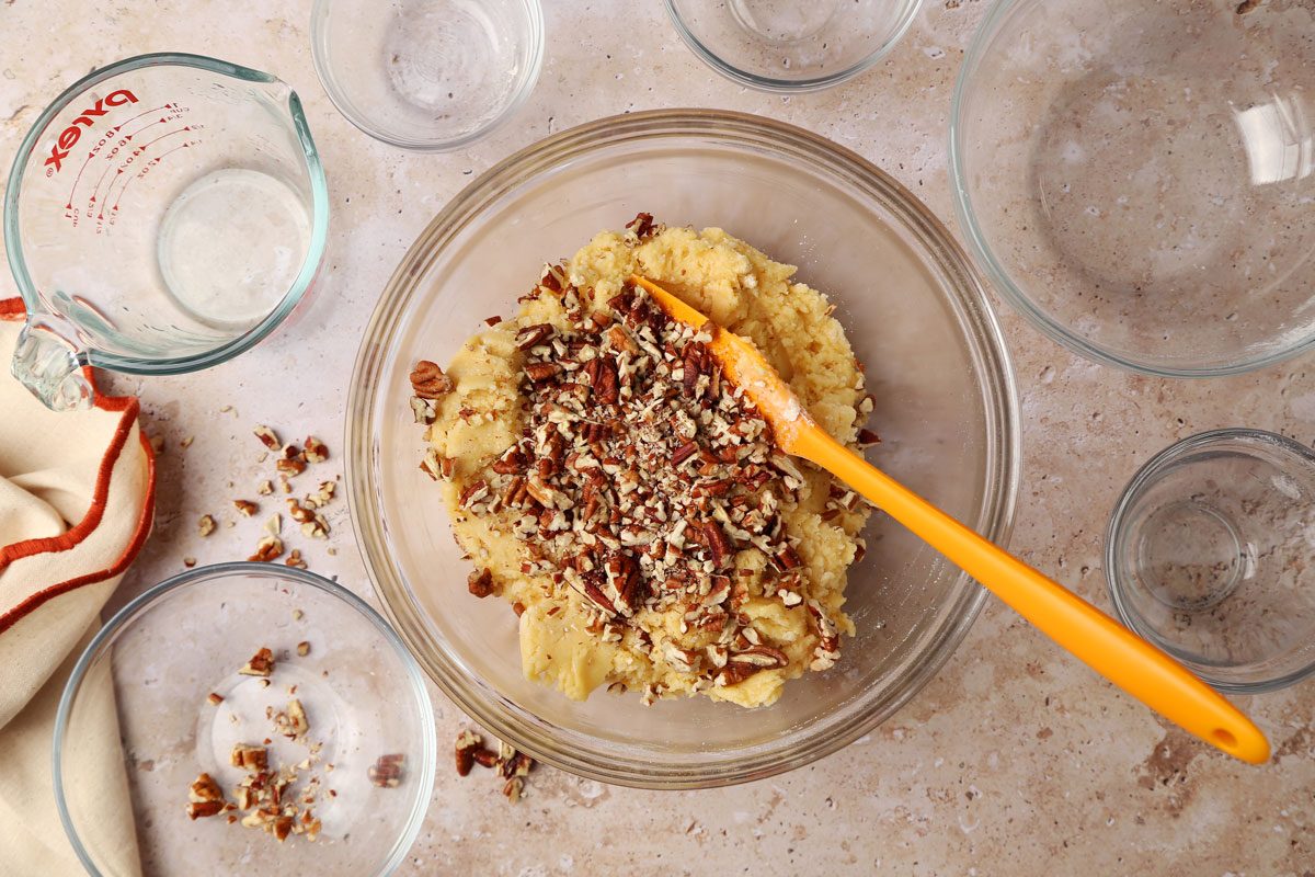 Mixing together ingredients for Taste of Home's Butterscotch Cookies in a large bowl on a brown marble surface.