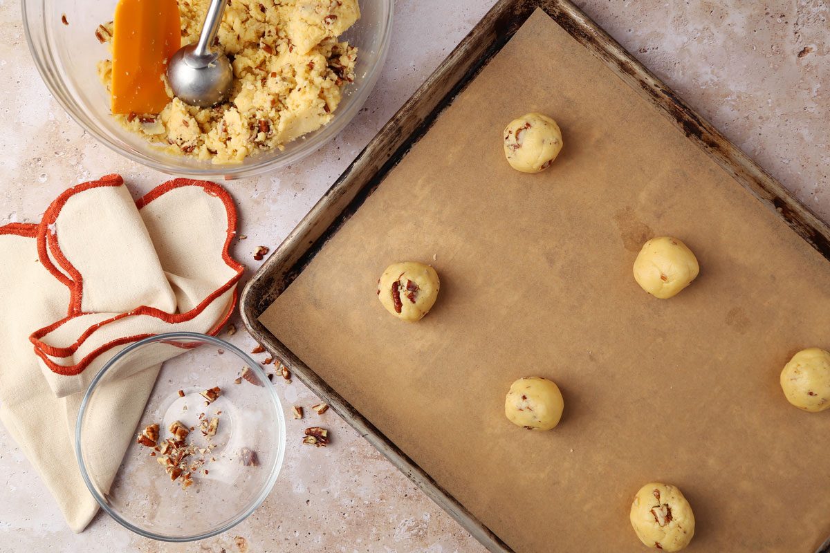 Mixing together ingredients for Taste of Home's Butterscotch Cookies in a large bowl on a brown marble surface.