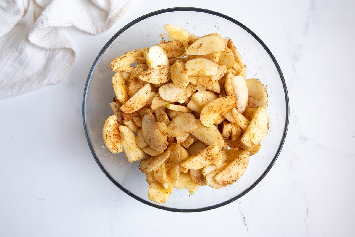 Overhead shot for Taste of Home Apple Streusel with apples and spices in a glass bowl.