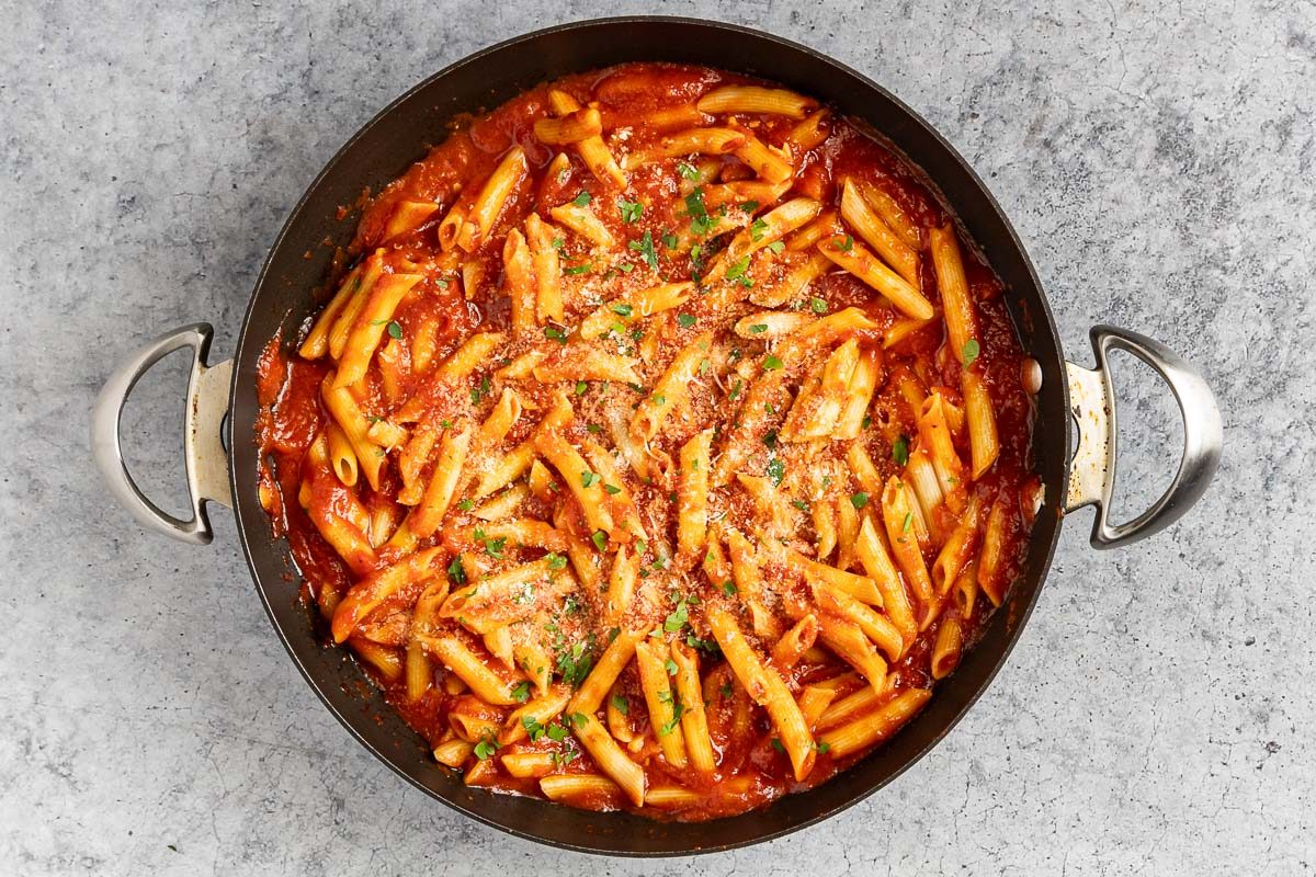 penne added to the sauce and topped with Parmesan cheese and fresh parsley.