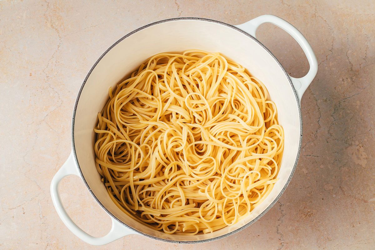 Cooked linguine pasta in a large pot for the Artichoke Tomato Pasta recipe by Taste of Home