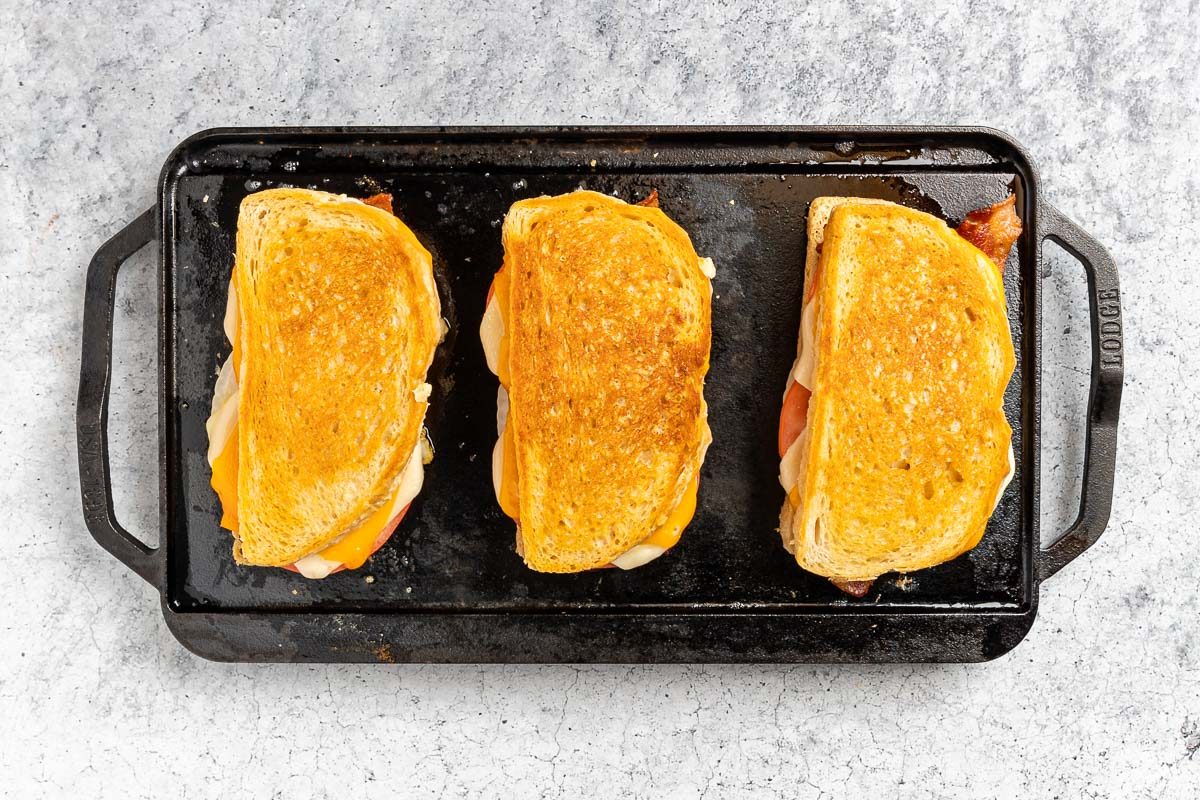 cooking the sandwiches on a cast iron griddle.