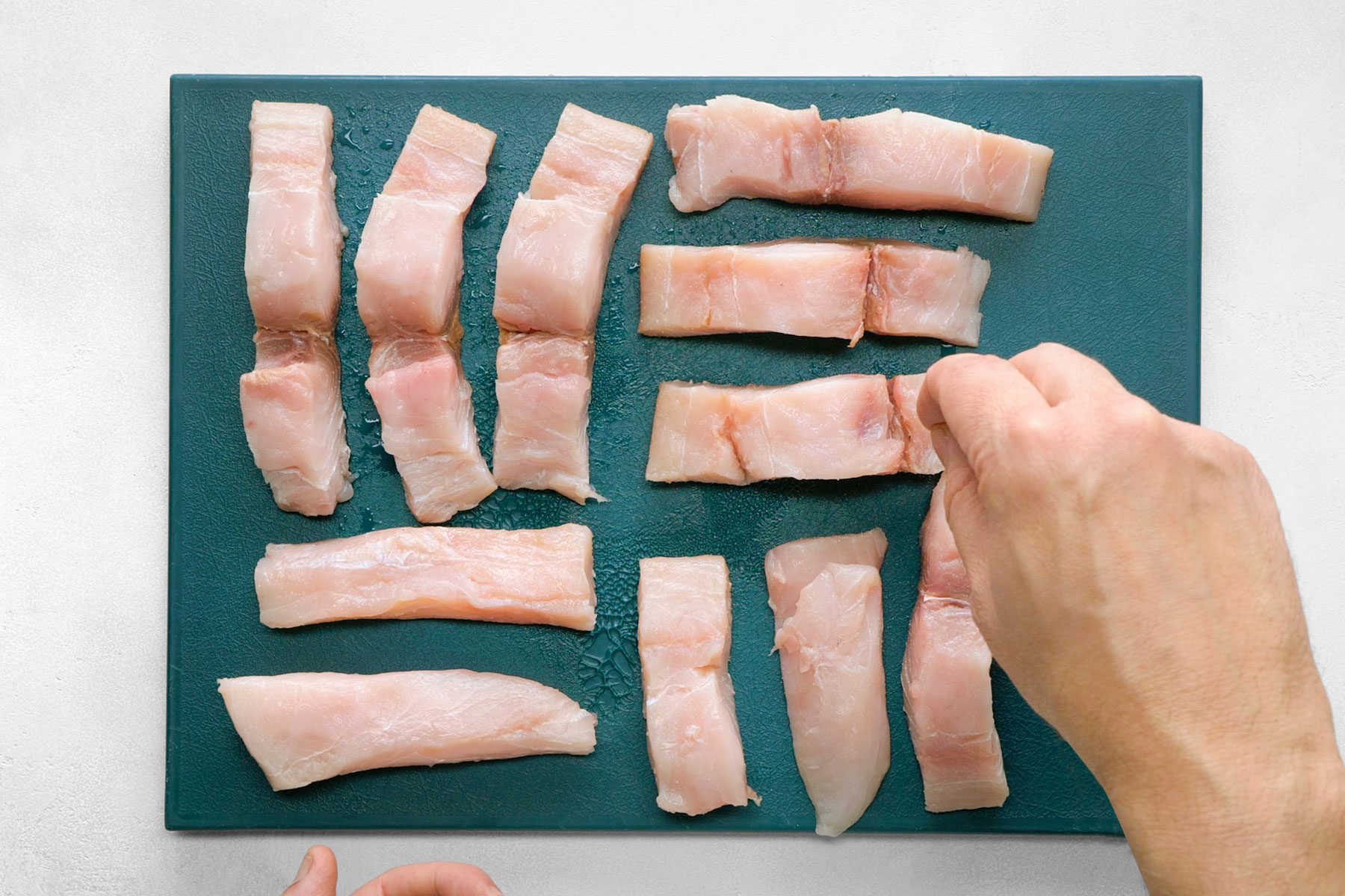 hand can be seen seasoning fish