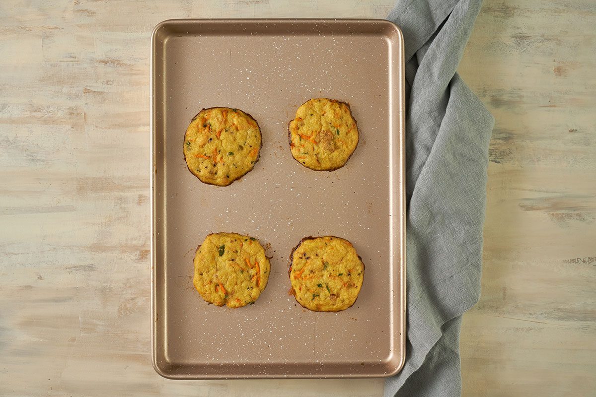 Overhead view of chilled crab cakes arranged on a baking sheet, baked until golden brown for the Taste of Home Baked Crab Cakes recipe.