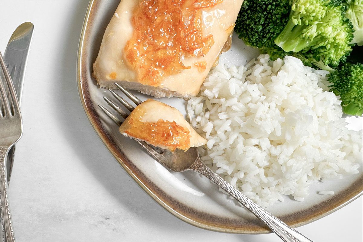 Taste of Home Baked Orange Chicken on a ceramic plate with white rice and steamed broccoli
