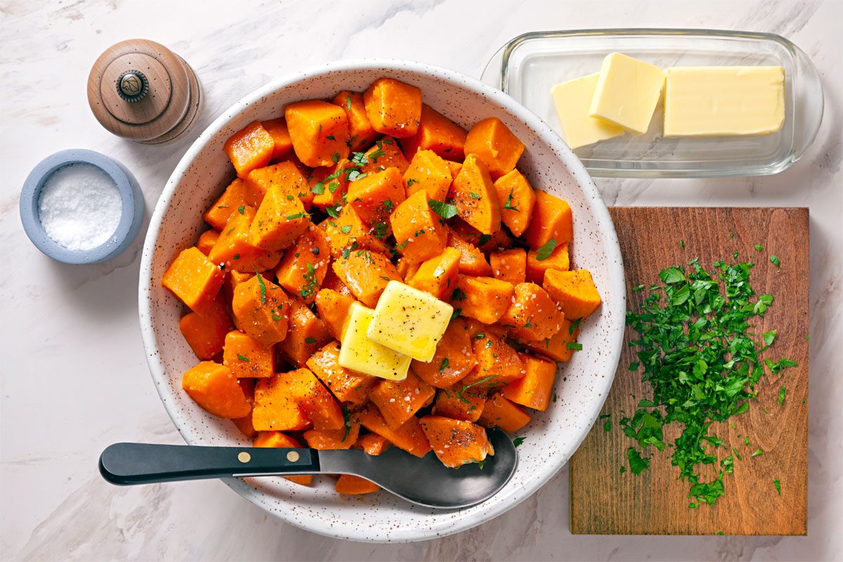 Boiled Sweet Potatoes garnished with parsley, butter and pepper