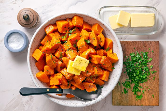 Boiled Sweet Potatoes garnished with parsley, butter and pepper