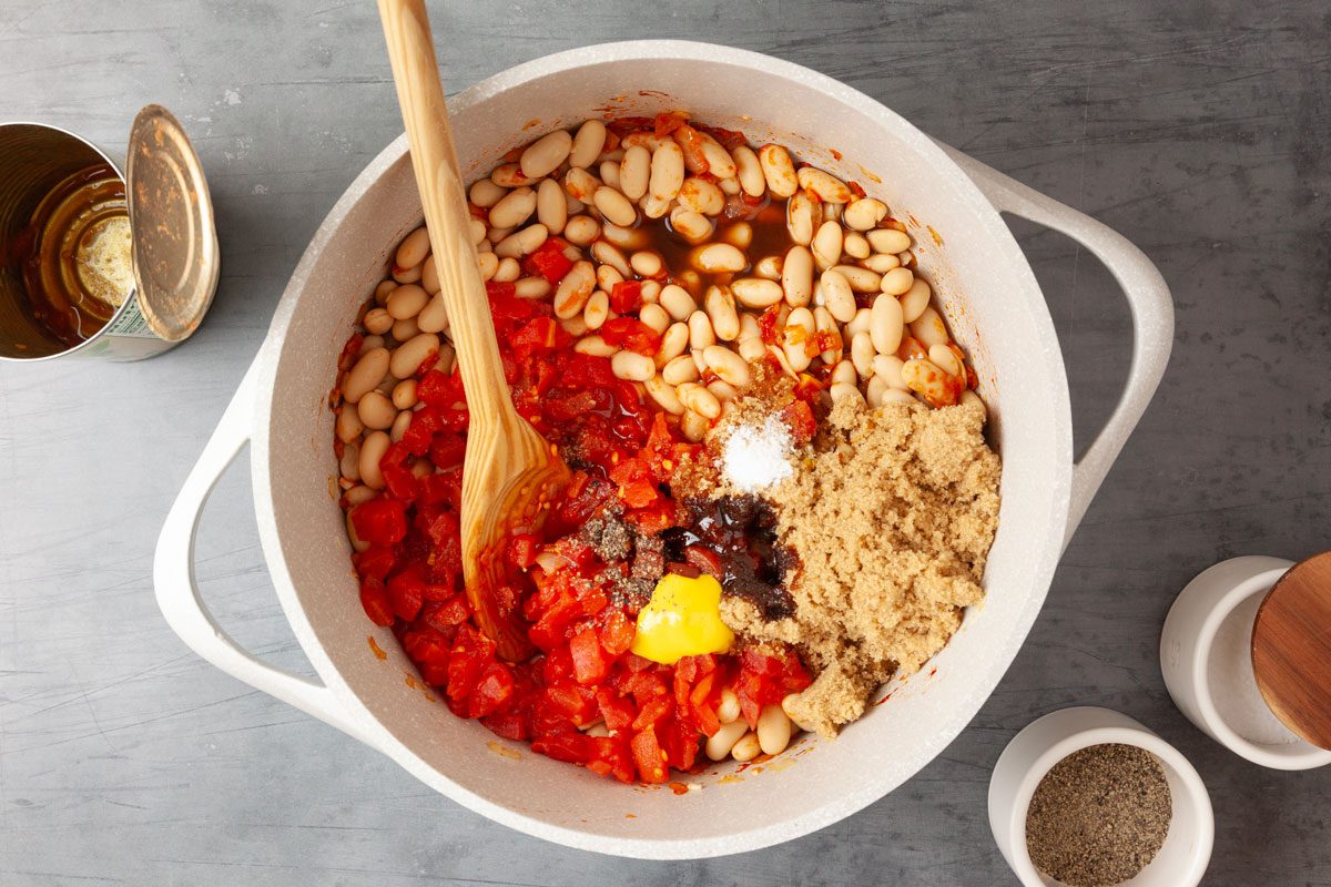Step 2 of Taste of Home British Baked Beans is to Stir in the navy beans, diced tomatoes, brown sugar, molasses, yellow mustard, cider vinegar, Worcestershire sauce, salt and pepper. Bring to a gentle simmer and cook for 15 to 20 minutes until the sauce is thick.