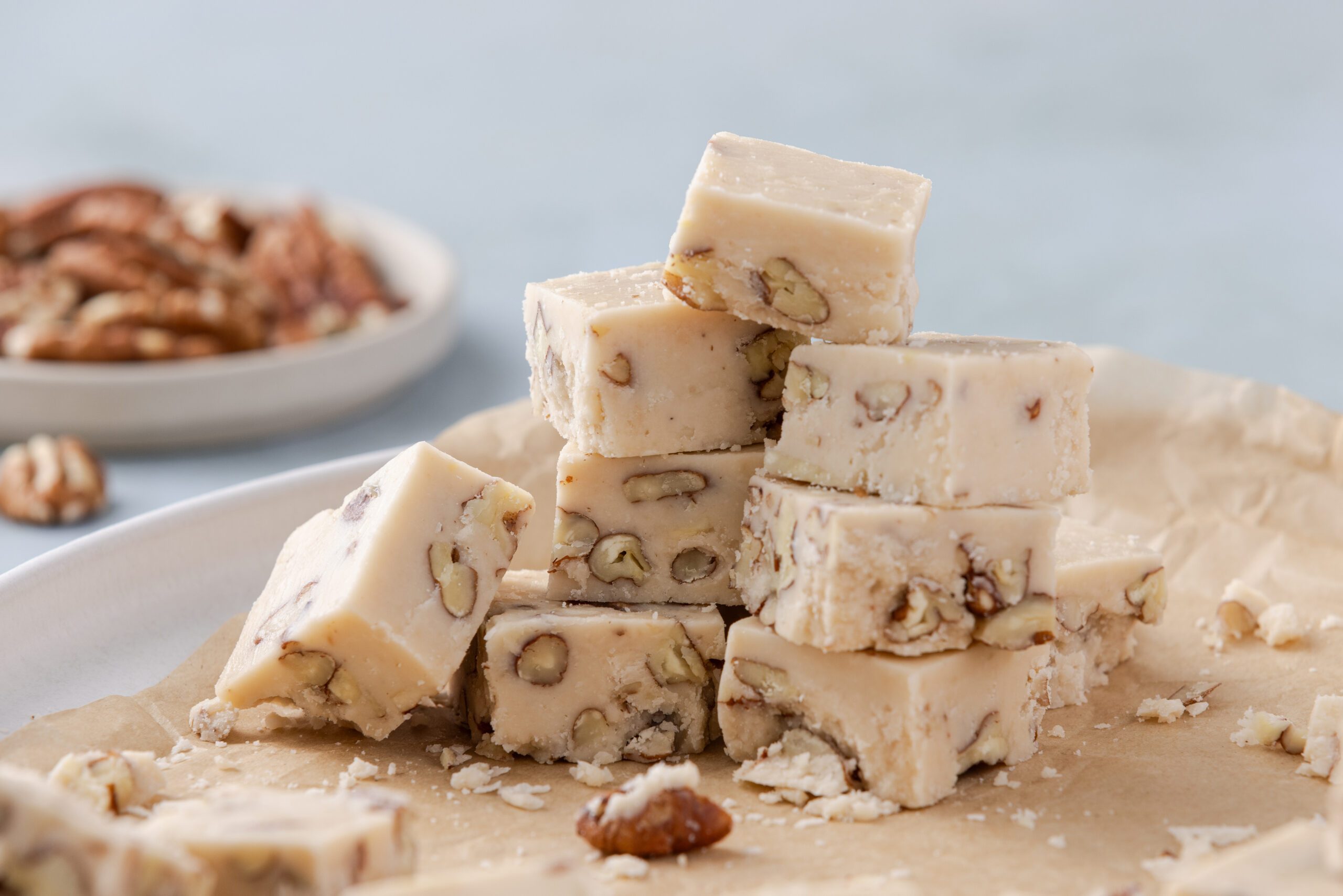 Butter pecan fudge ready, cut into 1 in squares and piled up on plate.