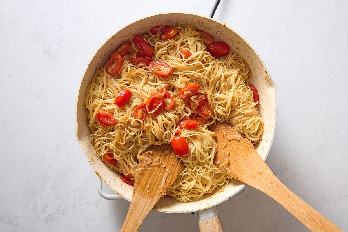 Stirring the cooked pasta into the other ingredients