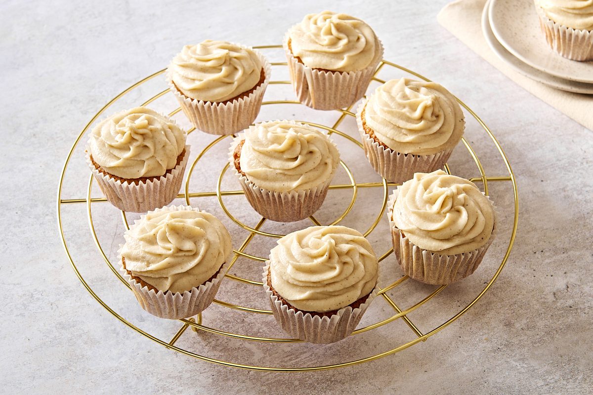 Frosted chai cupcakes on a circular wire rack