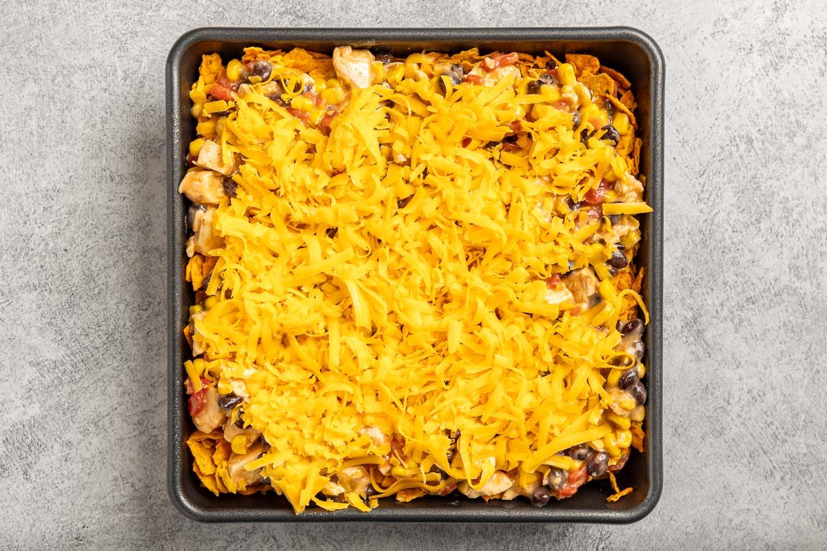 Taste of Home Chicken Doritos Casserole photo of the mixture layered with the Doritios in a 9x9 baking dish.