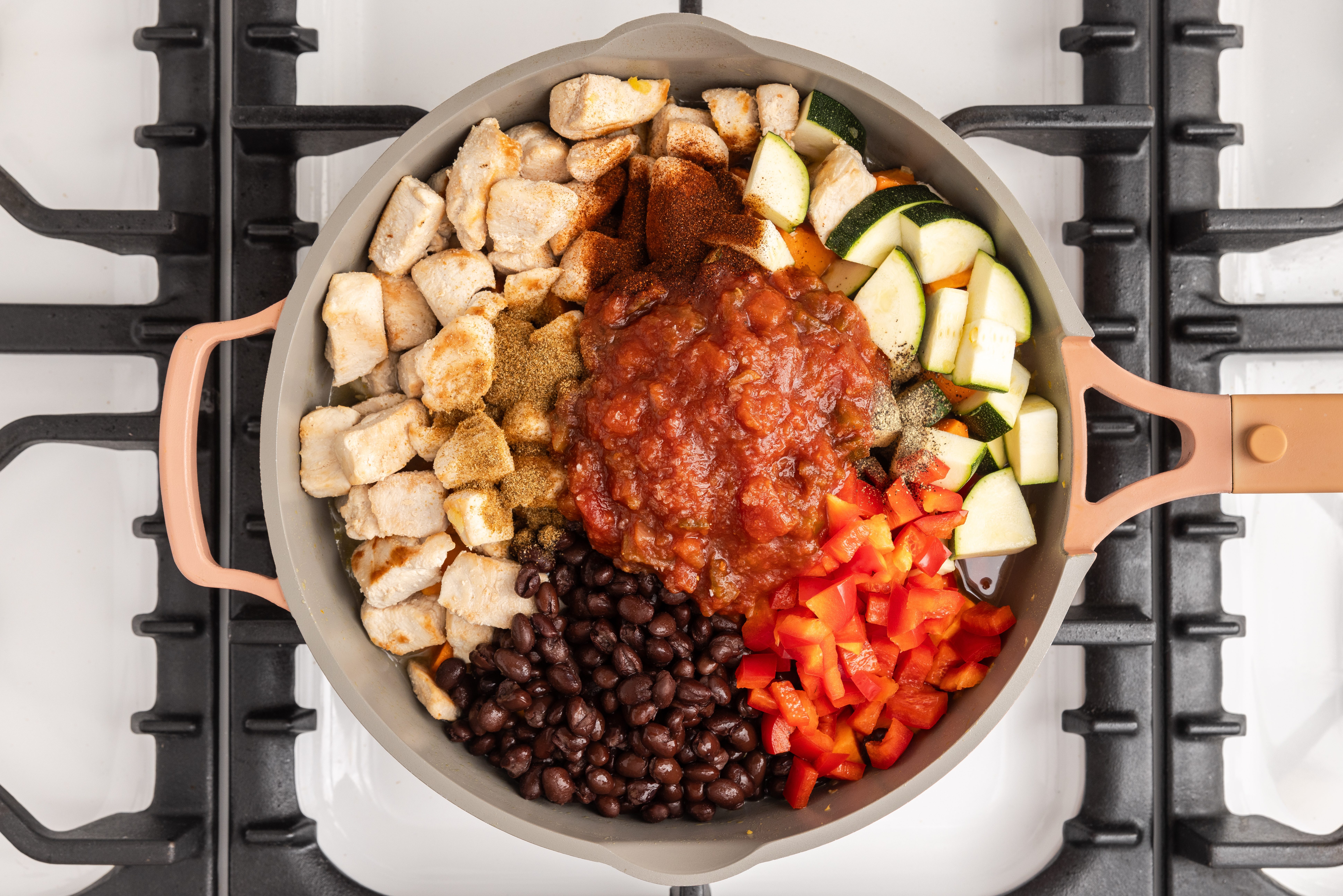 Vegetables and chicken on skillet being sauteed.