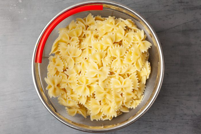 Step 1 of Taste of Home Chickpea Pasta Salad is to Cook the pasta according to the package directions. Drain it, rinse it in cold water and transfer it to a large bowl.