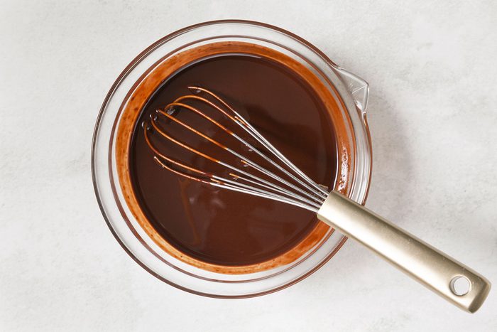 melted chocolate in a bowl with a whisk