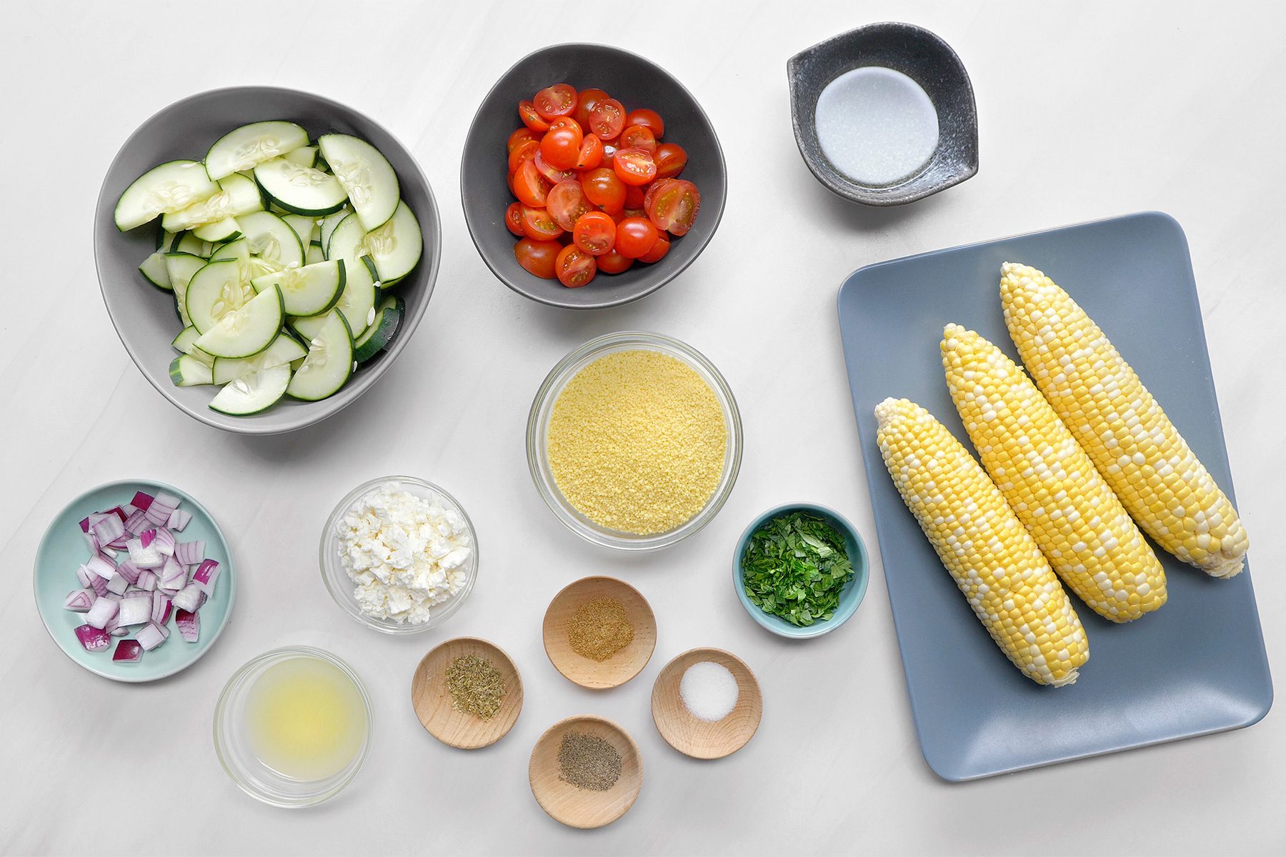 overhead shot of Couscous Salad ingredients placed over white background;