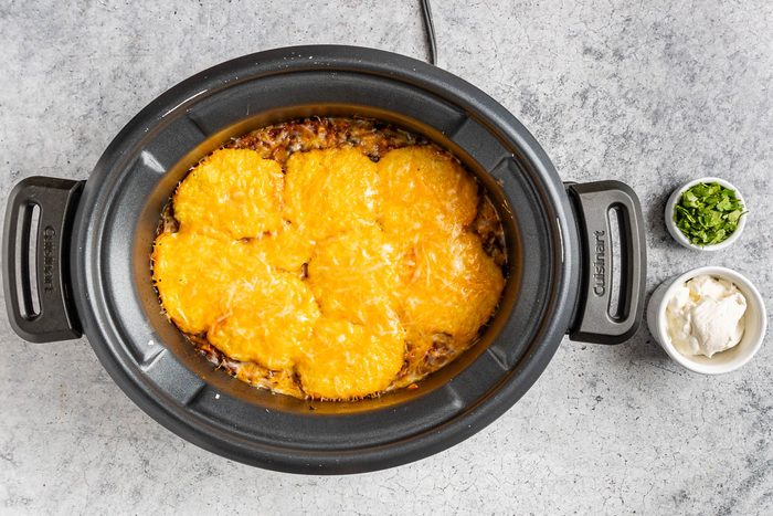 Taste of Home Crockpot Tamale Pie photo of topping the ingredients with cheese.