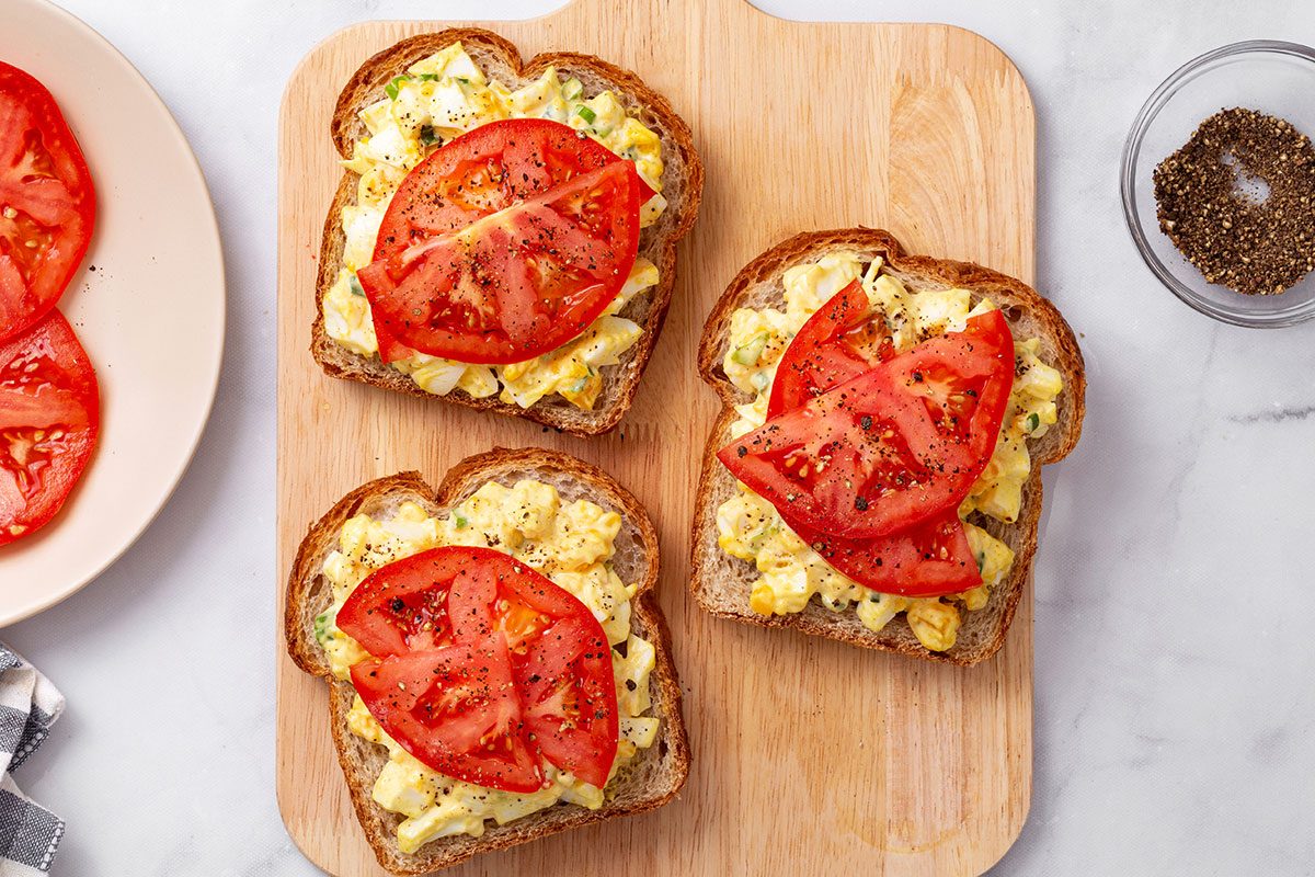 Curried Egg Salad sandwiches on a wooden cutting board for Taste of Home