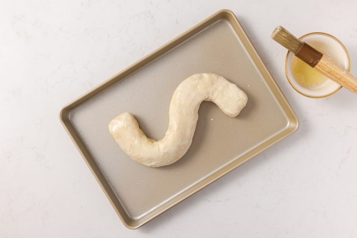 Dutch letter being coated with egg wash before going into the oven.