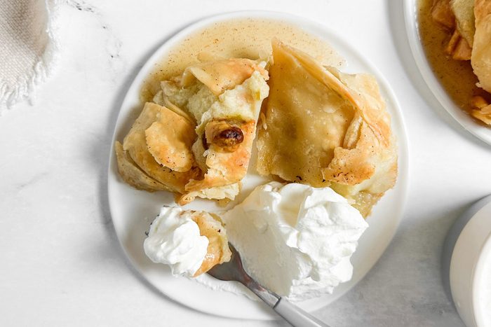 Taste of Home Easy Apple Dumplings on white plates with whipped cream