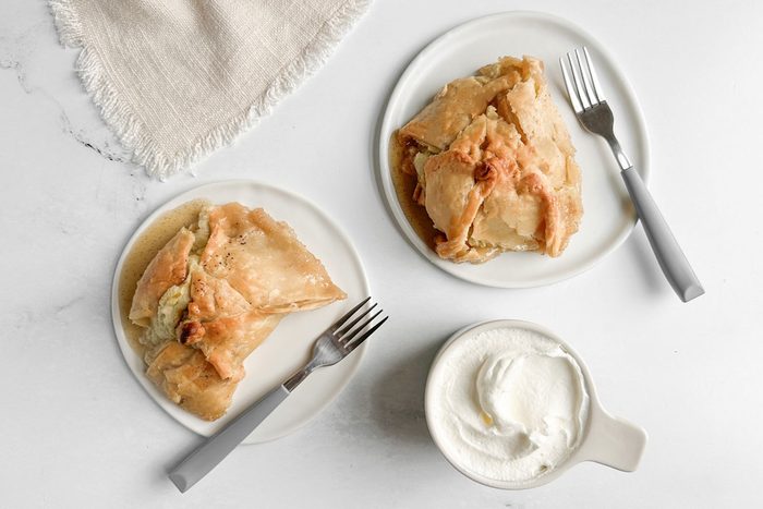 Taste of Home Easy Apple Dumplings on white plates with whipped cream